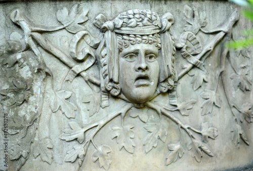 Decorative head in gray terracotta as a decoration on a bench in a garden in Seville, Spain. Ceramic decorative mask