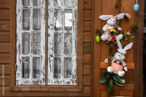 Casa do coelho da páscoa e madeira com janela branca no estilo vintage e coelhos pendurados na janela. photo
