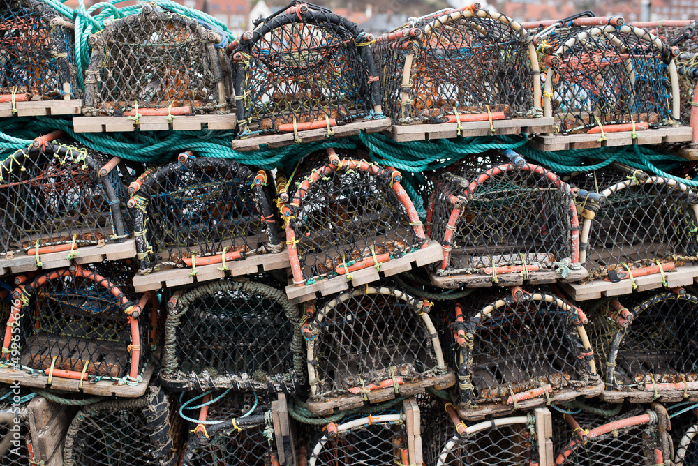 Crab traps stacked on top of each other, tied with a rope, prepared to be loaded onto a fishing boat. Crab traps stacked on top of each other, tied with a rope, prepared to be loaded onto a fishing boat.
