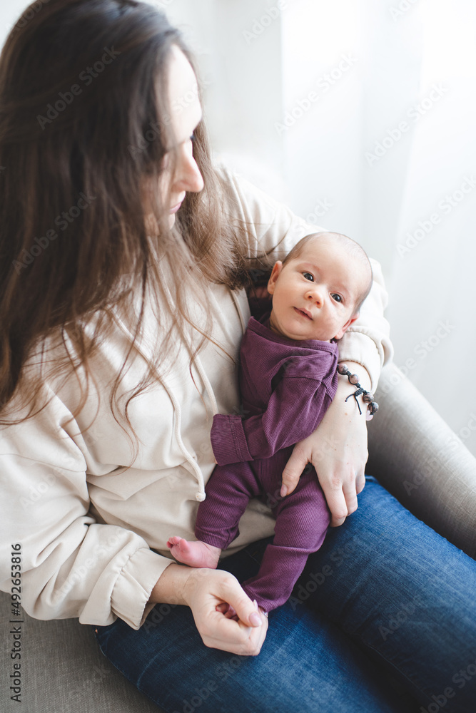 Young mother holding newborn child lying on hands in room at home. Family lifestyle concept. Motherhood. Young mother holding newborn child lying on hands in room at home. Family lifestyle concept. Motherhood.