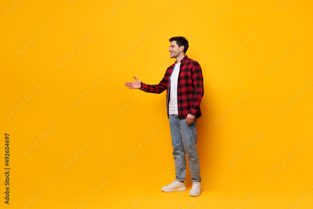 Fototapeta premium Portrait of happy young man posing at yellow studio