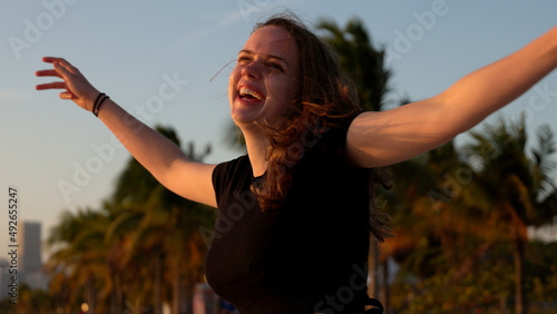 Happy woman enjoys the wonderful sunset at the beach of Miami