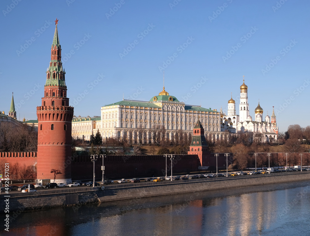 Vodovzvodnaya tower and Grand Kremlin Palace of Moscow Kremlin behind the wall on embankment ot the riverin in bright spring sunny day with clear blue sky