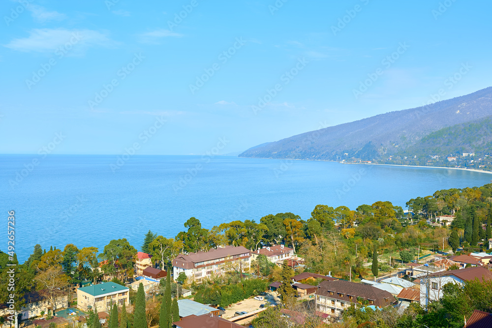 View from a height of the bay of old Gagra in the bright daytime sun. Autumn in Abkhazia.
