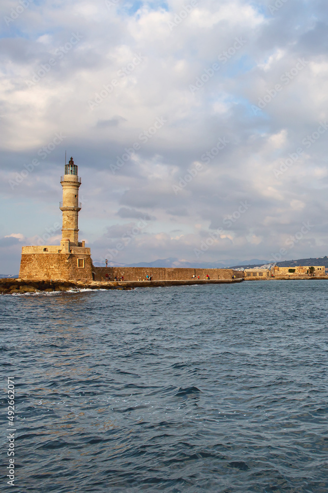 view from the sea to the old stone lighthouse in the small Greek resort town of Rethymno