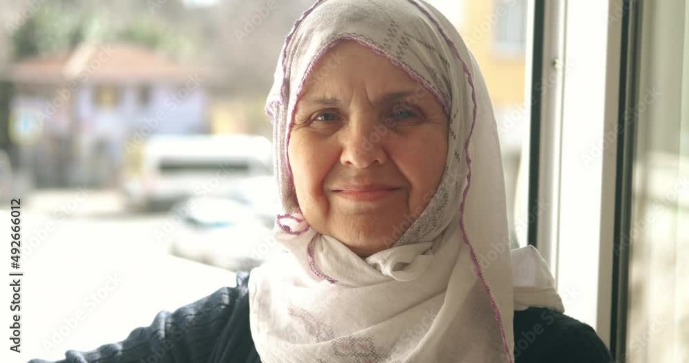 An old Turkish woman is wearing headscarf, hijab. Smiling to camera, Portait of muslim retired woman. Islamic culture, old woman is praying concept. An old Turkish woman is wearing headscarf, hijab. Smiling to camera, Portait of muslim retired woman. Islamic culture, old woman is praying concept.