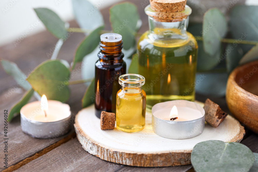 Assortment of natural oils in glass bottles on wooden background. Concept of pure organic ingredients in cosmetology. Bath accessories, atmosphere of harmony, relax. Close up macro. Healthy lifestyle Assortment of natural oils in glass bottles on wooden background. Concept of pure organic ingredients in cosmetology. Bath accessories, atmosphere of harmony, relax. Close up macro. Healthy lifestyle