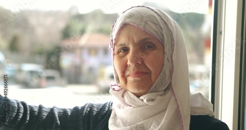 An old Turkish woman is wearing headscarf, hijab. Smiling to camera, Portait of muslim retired woman. Islamic culture, old woman is praying concept.