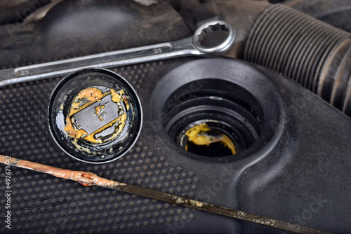 The thick, greasy yellow motor oil under oil cap as signs and symptom of a blown head gasket