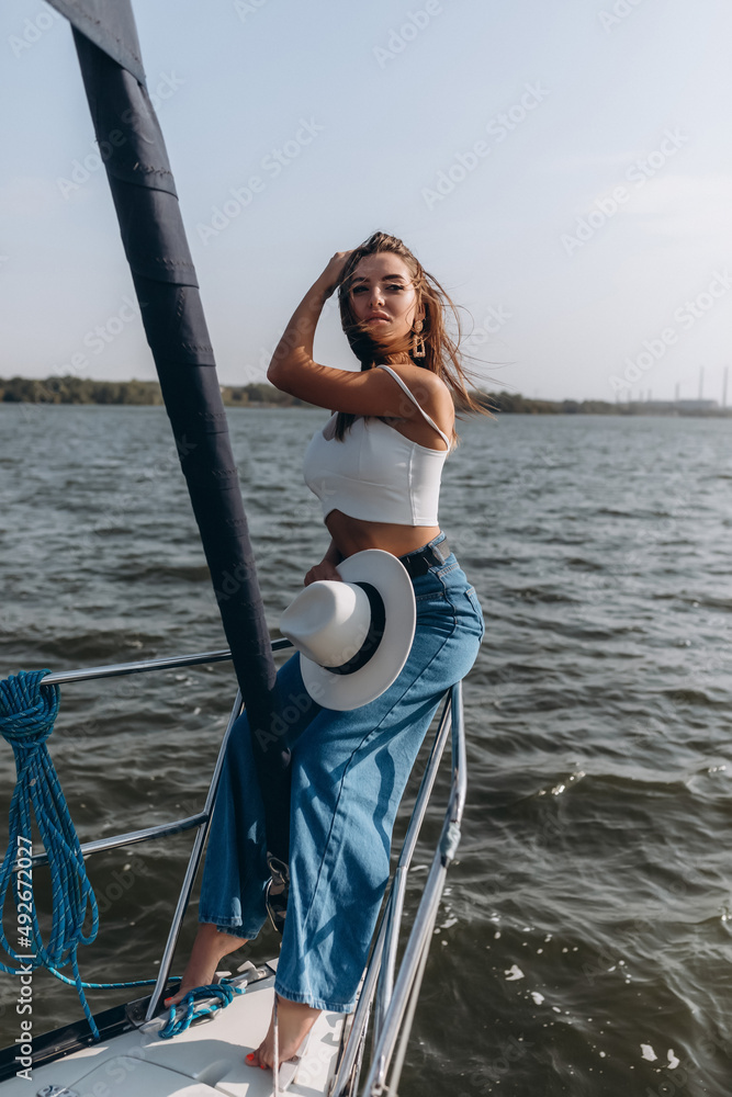 beautiful young woman in a hat stands on a yacht beautiful young woman in a hat stands on a yacht