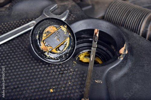 The thick, greasy yellow motor oil under oil cap as signs and symptom of a blown head gasket