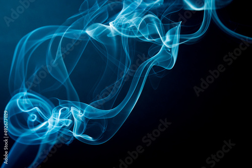 Abstract beautiful smoke against black background. Swirling movement of smoke. Toxic movement of white and blue smoke on black background. 