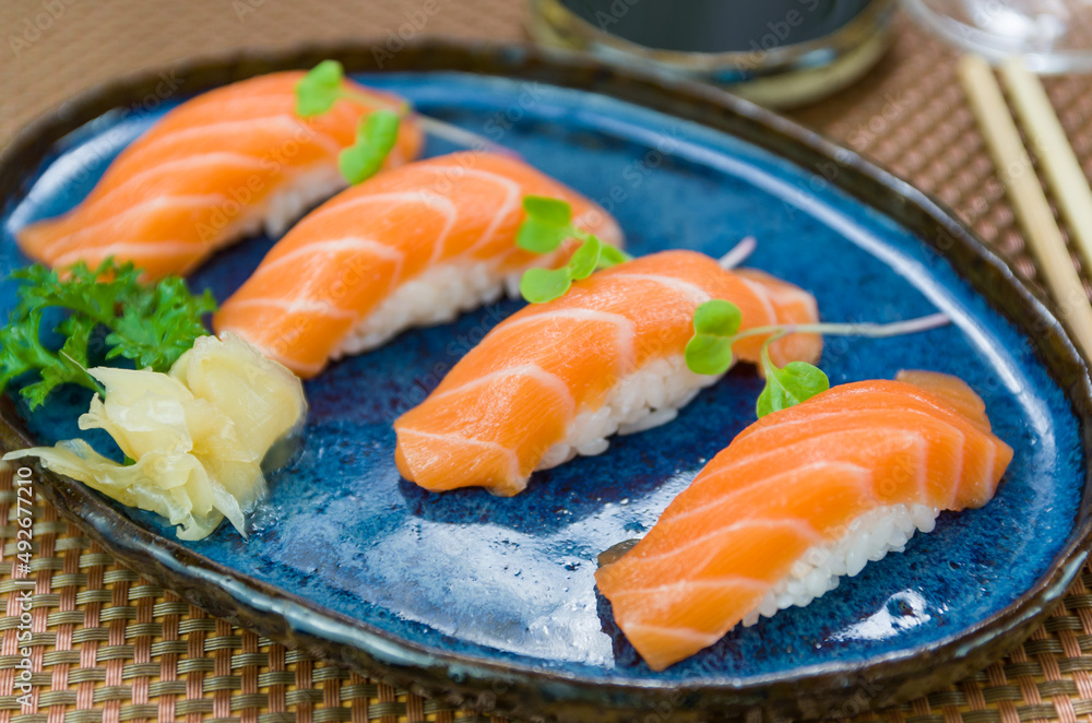 Delicious premium salmon nigiri on blue plate Delicious premium salmon nigiri on blue plate