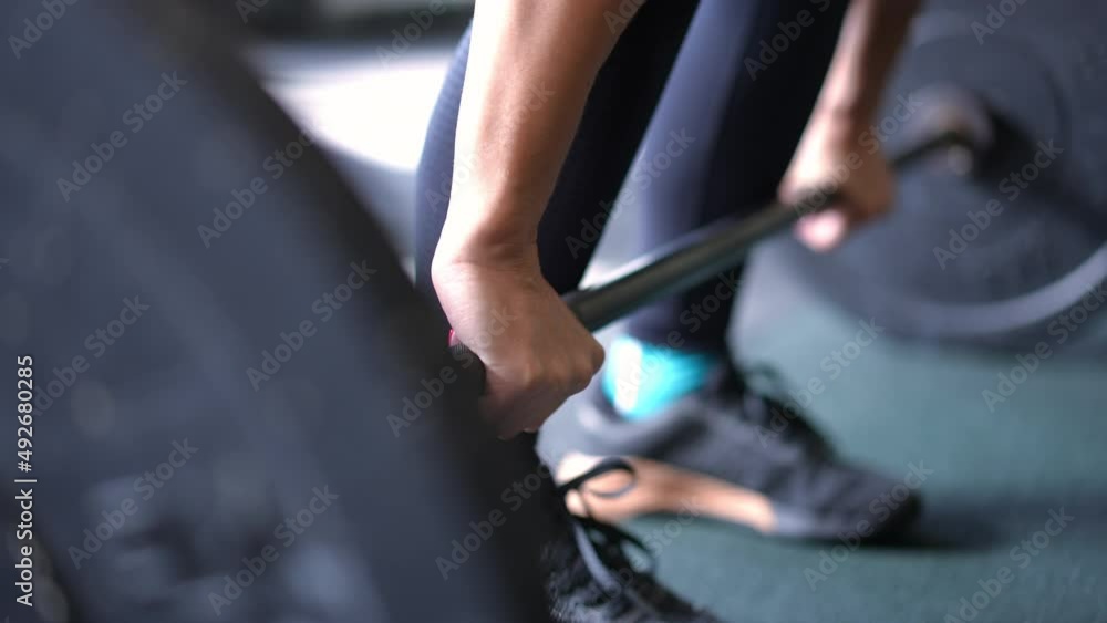 Close-up female hands lifting heavy barbell in gym indoors. Unrecognizable Caucasian sportswoman powerlifting sportive equipment. Gender equality and bodybuilding concept Close-up female hands lifting heavy barbell in gym indoors. Unrecognizable Caucasian sportswoman powerlifting sportive equipment. Gender equality and bodybuilding concept