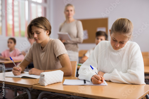 School lesson - students write down assignments while sitting at their desks