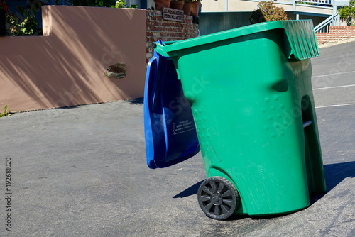 green garbage wheely bin on the street photo