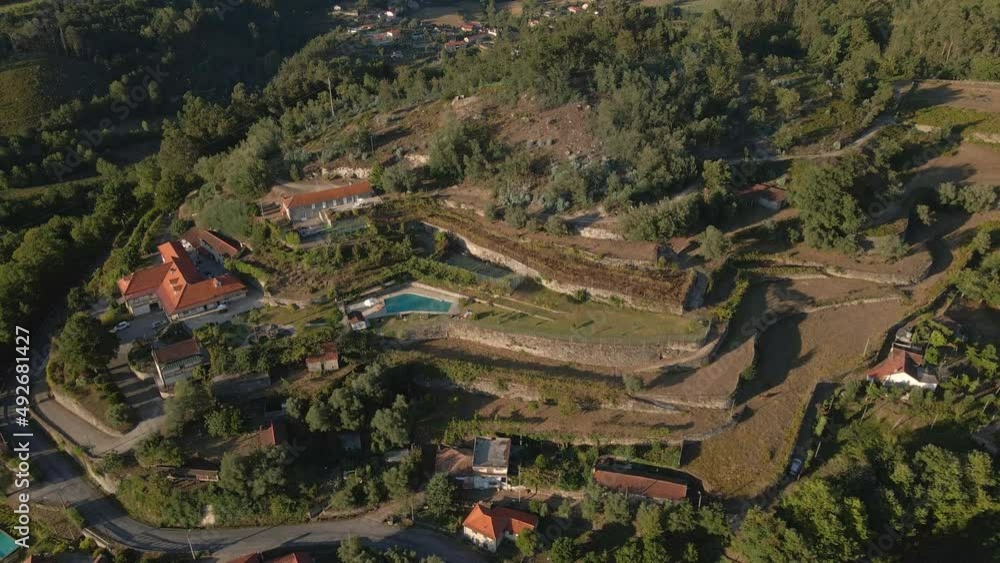 Aerial view of a small village in the mountains. Rural portuguese houses with red roofs and swimming pool, in north of Portugal Aerial view of a small village in the mountains. Rural portuguese houses with red roofs and swimming pool, in north of Portugal