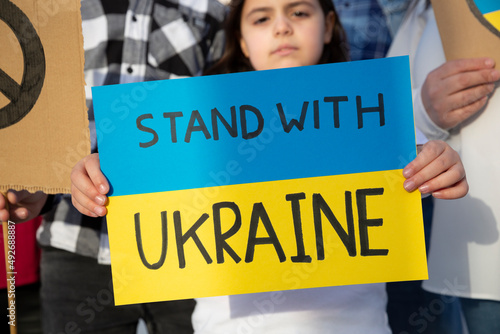 Little child holding a sign with a message of support for the Ukrainian people. Demonstration against the war. Free Ukraine.