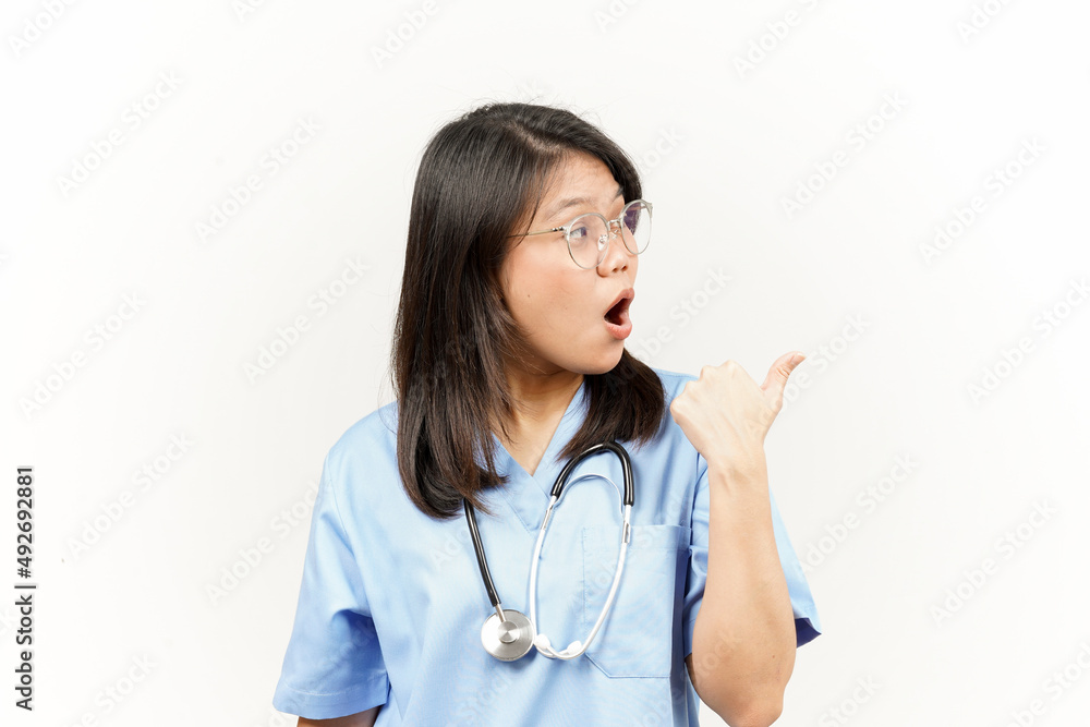 Showing and Pointing Product With Thumb Of Asian Young Doctor Isolated On White Background Showing and Pointing Product With Thumb Of Asian Young Doctor Isolated On White Background