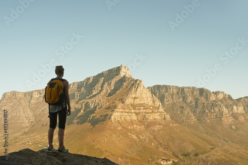 The view is reserved for the victor. Shot of a woman admiring the view from a mountain top.