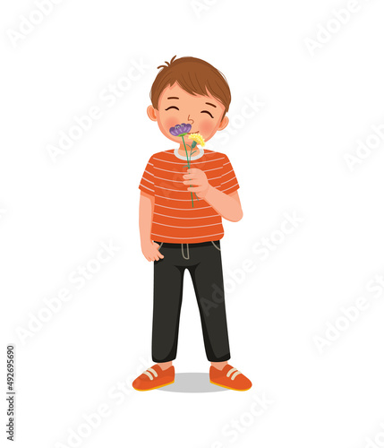 cute little child boy holding and smelling flowers enjoying the aroma 