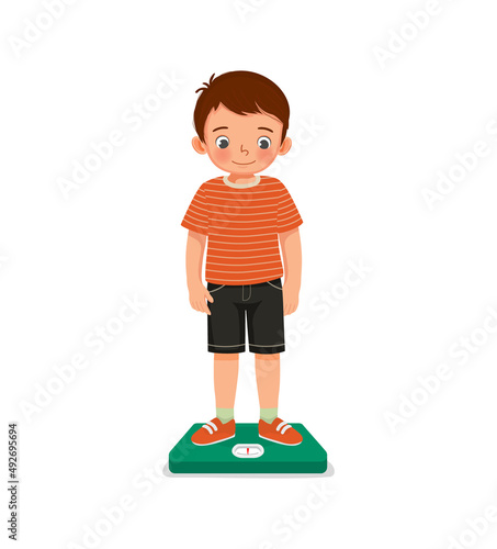 cute little boy child standing on the weighing scale checking his weight