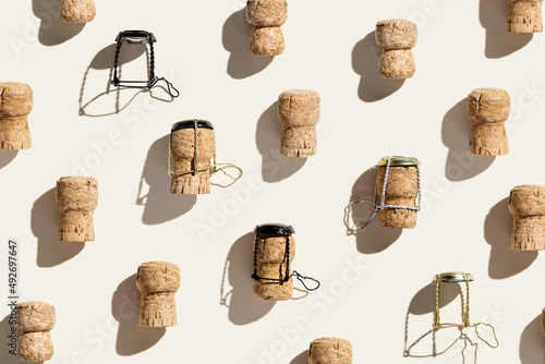 Creative pattern with champagne cork on beige background with hard light and shadows at sunlight. Minimal summer layout with bottle cap from sparkling wine and metal wire muselet, top view photo