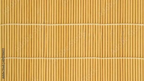 woven texture of light brown bamboo sticks with a vertical arrangement