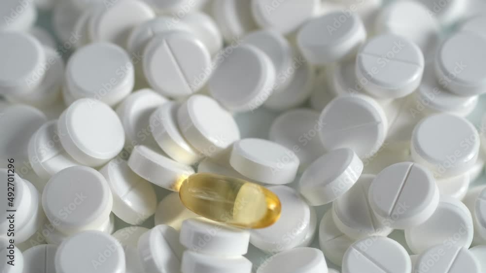 The medicine concept.white medical pills rotating closeup. Pills and drugs. Pharmaceutical Industry.many white round pills. pharmaceutical production. drugs on the production line. moving background The medicine concept.white medical pills rotating closeup. Pills and drugs. Pharmaceutical Industry.many white round pills. pharmaceutical production. drugs on the production line. moving background