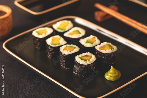 sushi roll sul piatto nero con le bacchette	 photo