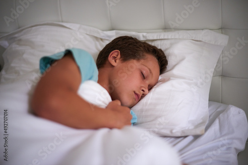 Bedtime is important for a growing boy. A little boy asleep in his bed.