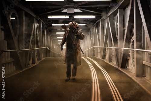 A man standing in the dark underground bridge with very dramatic and vintage lighting. Fictional or game character.