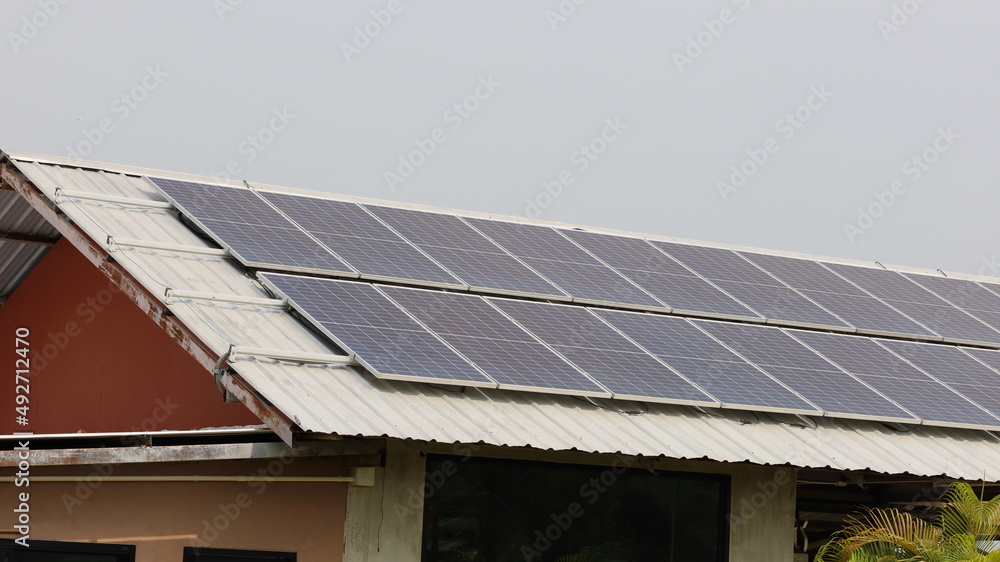 Solar panels on the roof. Photovoltaic modules for generating renewable energy on the roof of your home or office with copy space. Clean energy concept. Selective focus Solar panels on the roof. Photovoltaic modules for generating renewable energy on the roof of your home or office with copy space. Clean energy concept. Selective focus