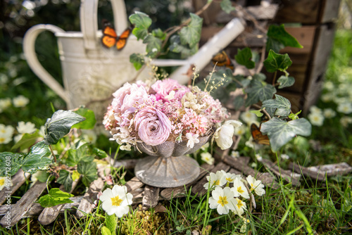 Bouquet of flowers in the backyard and watering can. Selective focus on flowers to create a shallow depth of field.