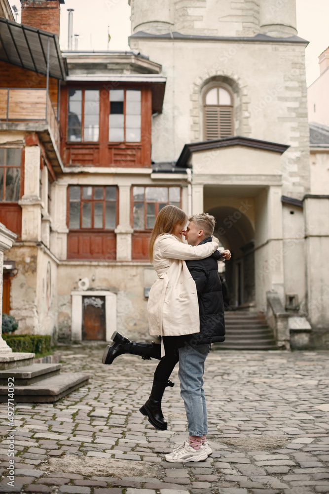 Romantic couple hugging and kissing in the street of old town