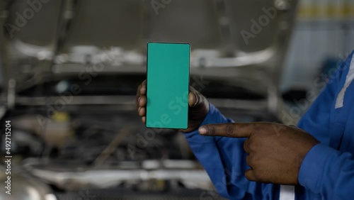 Wallpaper Mural close shot of car machanic hands using green screen mobile phone with uniform in front of car - concept of online booking service, advertisement and application promotion. Torontodigital.ca