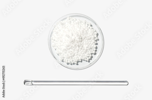 Carbamide in Chemical Watch Glass placed next to stirring rod. Closeup chemical ingredient on white laboratory table. Top View