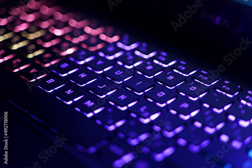 Neon computer keyboard with color backlight. Computer video games, hacking, technology, internet concept. Selected focus.