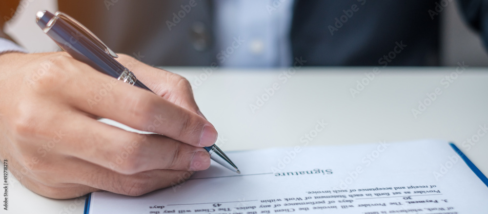 man signing on contract documents after reading, man holding pen and approve on business report. Contract agreement, law and deal concepts man signing on contract documents after reading, man holding pen and approve on business report. Contract agreement, law and deal concepts