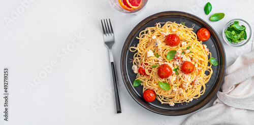 Pasta with feta, cherry tomatoes and basil on a gray background. Fetapasta.