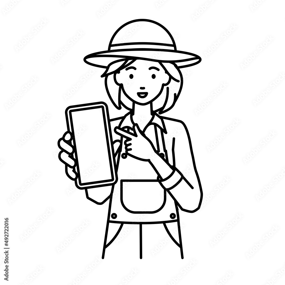 立ってスマートフォンを指差してこちらに向けて見せている農家の女性