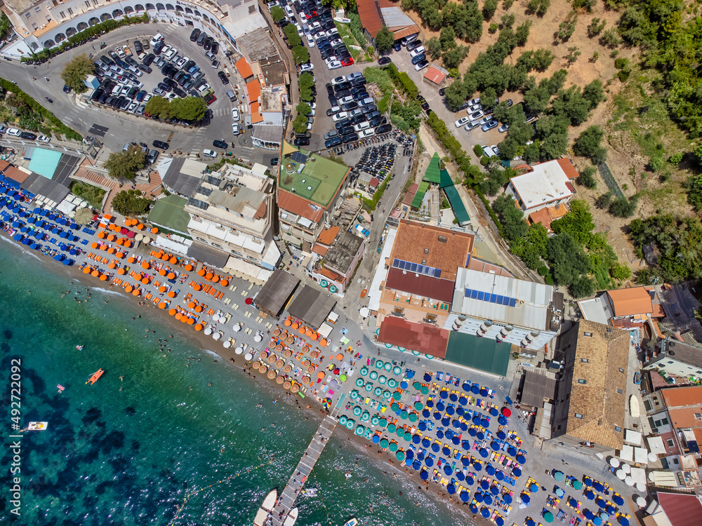 Overhead aerial view of Marina del Cantone Beach on a sunny day, Amalfi Coast - Italy. Beach Umbrellas downward view.