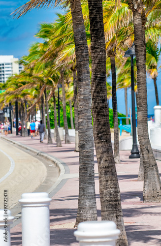Seafront beach promenade with palm trees on a sunny day in Fort Lauderdale.