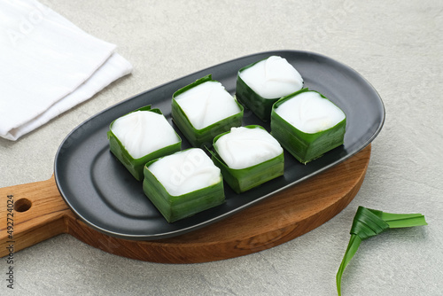 Kue talam or Talam cake made from combination of rice flour, sugar, and coconut milk. Served on plate on grey background.
 photo