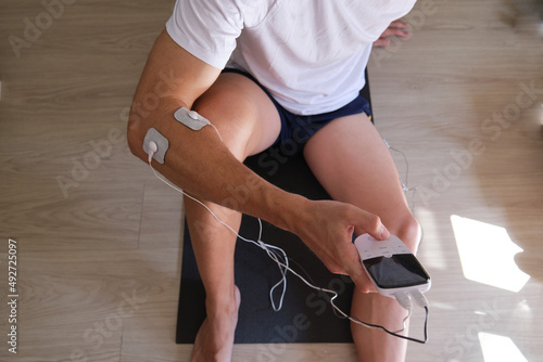 electrostimulation treatment, electrodes on the elbow, tens or ems treatment to reduce inflammation and improve blood circulation. rehabilitation. epicondylitis photo