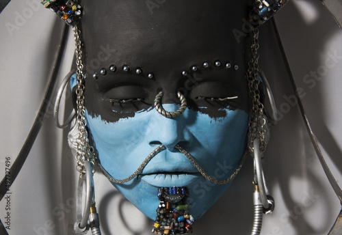 Indigenous face sculpture. Close-up of statue, portrait of person with African features. Artwork with incorporation of recycled materials. photo