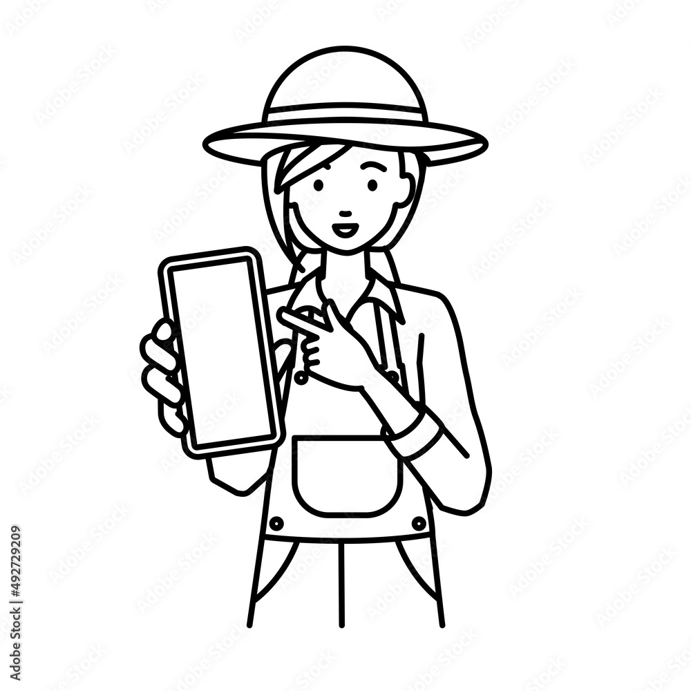 立ってスマートフォンを指差してこちらに向けて見せている農家の女性