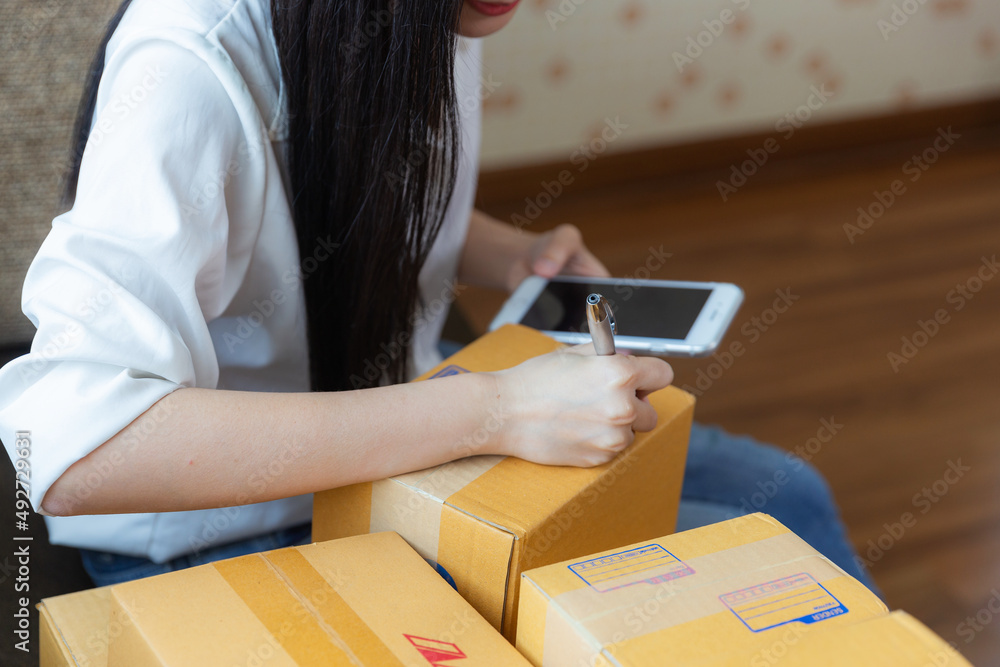 Asian young woman startup small business online at home and packing box for delivery online to customer. Asian young woman startup small business online at home and packing box for delivery online to customer.