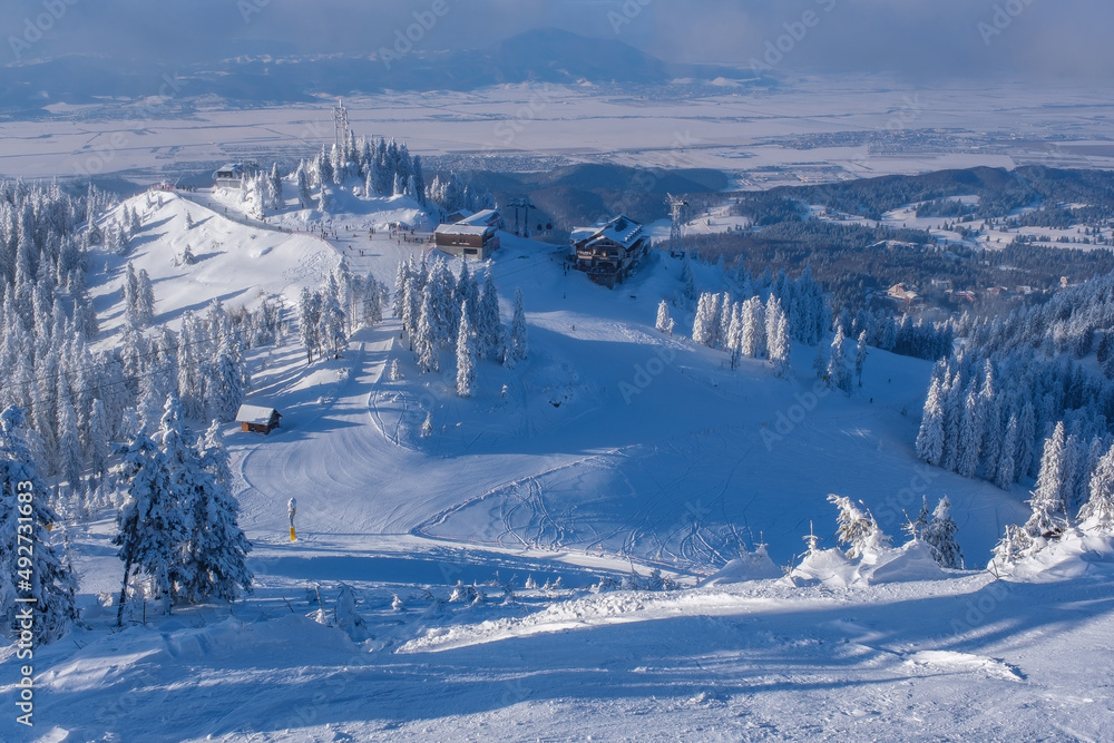 Scenic winter wonderland. Ski resort in full season. Frozen trees covered in snow mountain landscape. Ski cable car challet