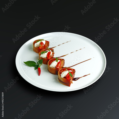 traditional dishes of European cuisine, delicacy, banquet snack. culinary dishes on a white plate on a black background. restaurant service photo